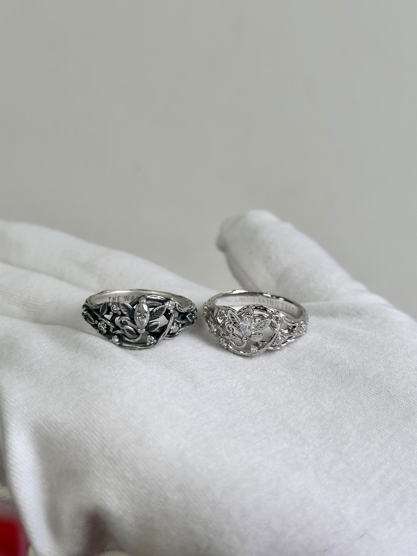Two Waking Tree rings, oxidized and bright silver, resting on a white glove